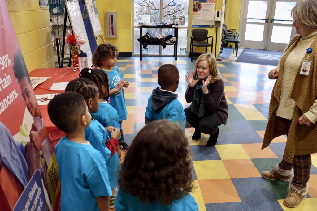 A photo of Lt. Governor Gay at an early education summer camp making silly faces with the children in blue shirts.