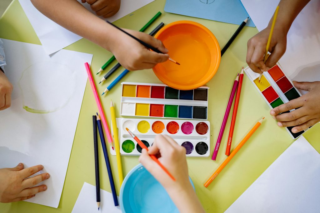 A photo of young children's hands painting.